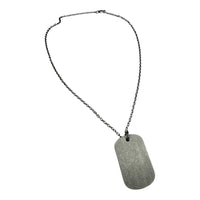 Necklace with a textured metal tag on a white background