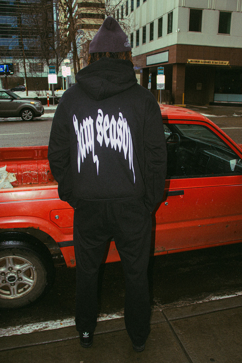 Black hoodie and sweatpants streetwear outfit worn by model, relaxed fit with minimalist design